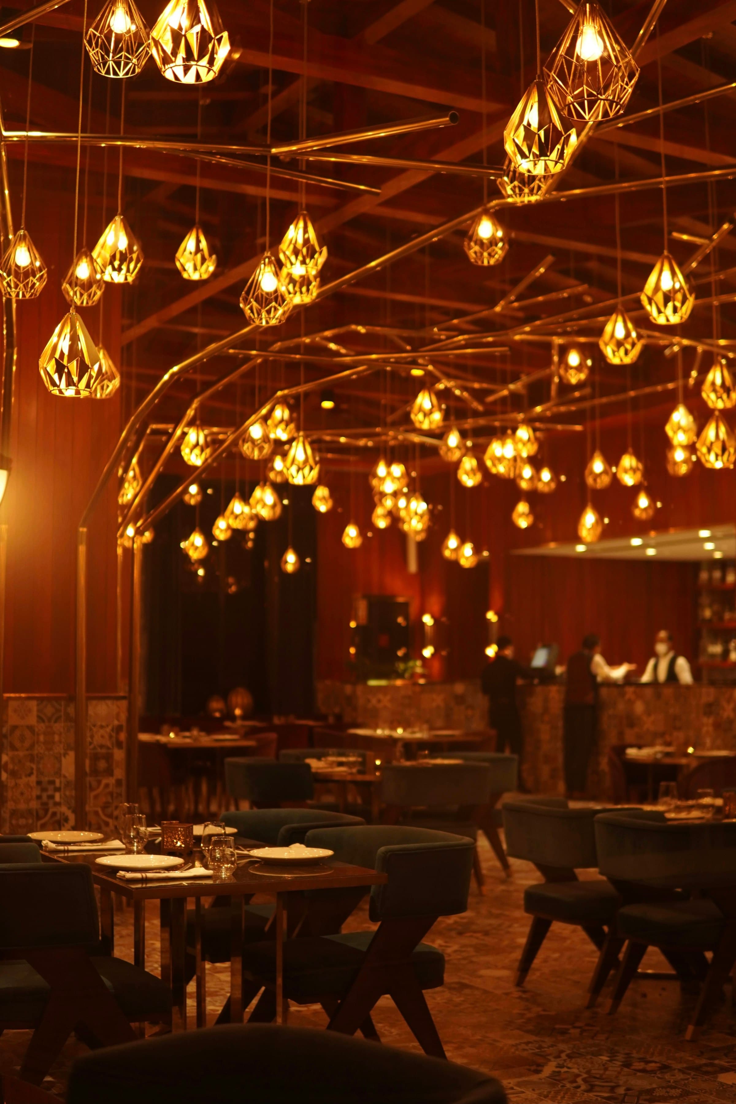 Warm, cinematic hospitality interior with sculptural pendant lighting