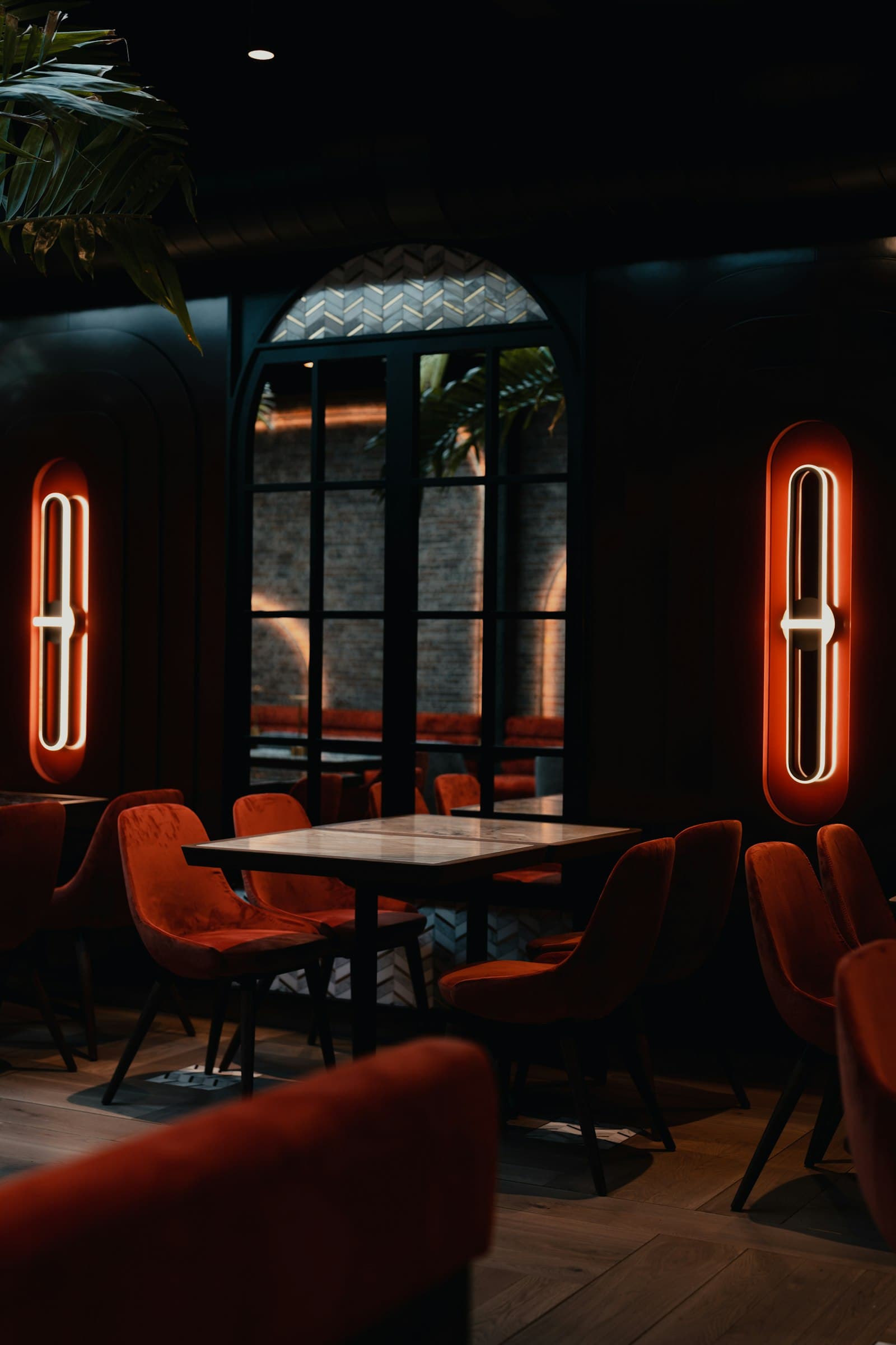 Bold Italic restaurant interior with velvet chairs and neon wall sconces